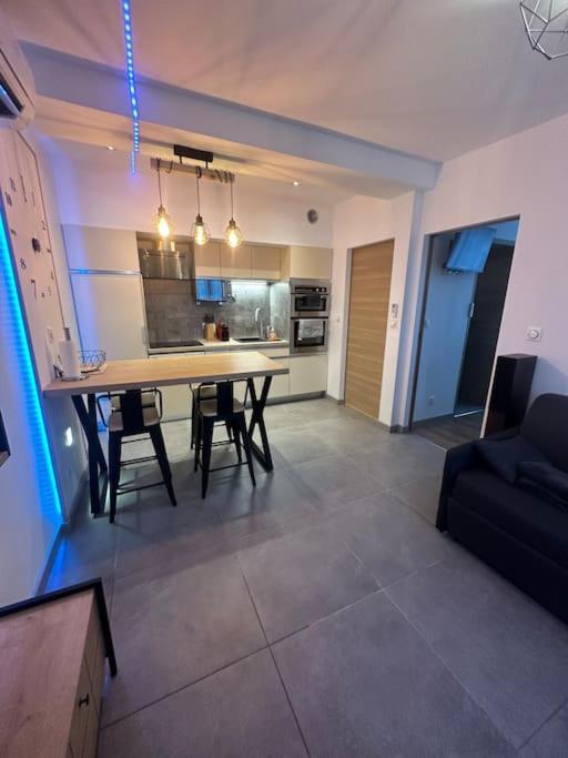 Il comprend un salon avec une table à manger et une cuisine. dans l'établissement Magnifique T2 Meyzieu neuf charme et élégance, à Meyzieu