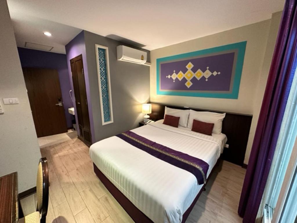 een slaapkamer met een groot bed in een kamer bij Sawasdee Hotel @ Sukhumvit Soi 8 in Bangkok
