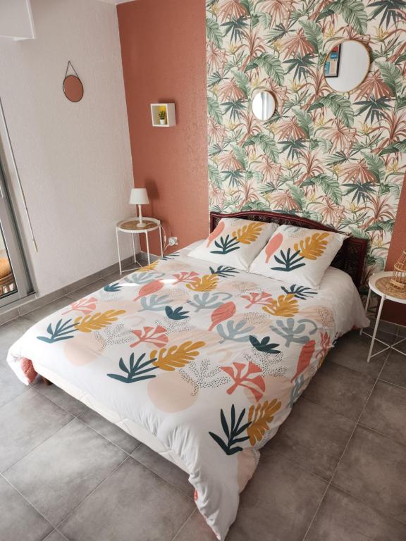 - une chambre avec un lit orné de motifs floraux dans l'établissement joli studio rénové dans station balnéaire., à Saint-Mandrier-sur-Mer