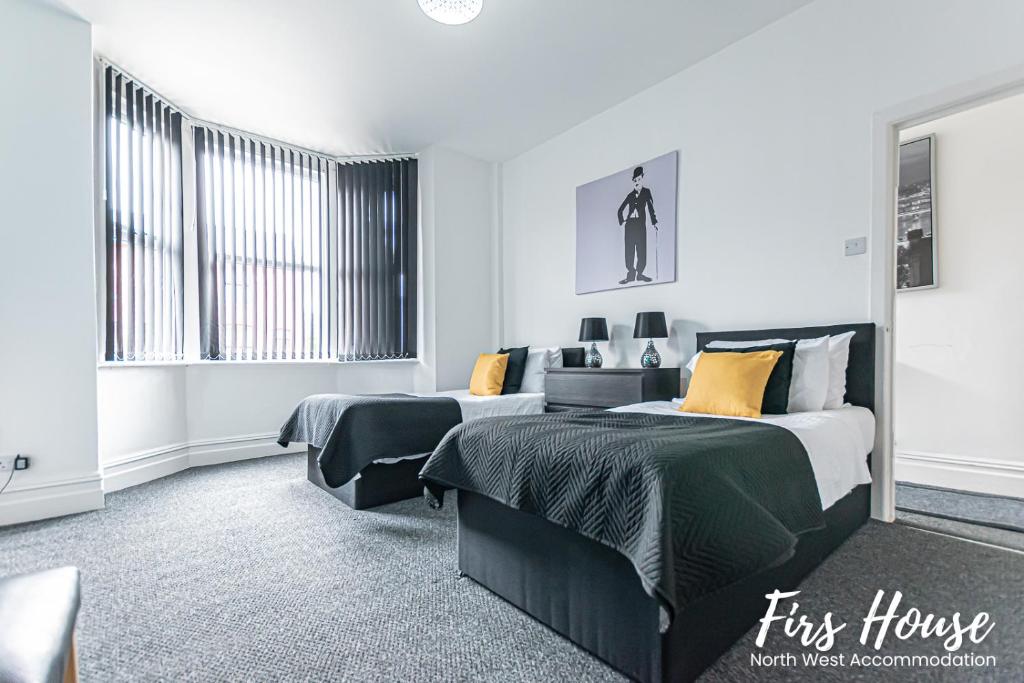 a bedroom with two beds and a couch at Firs Serviced Accommodation in Leigh