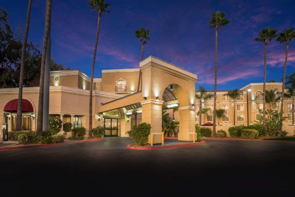 een weergave van de voorkant van een hotel met palmbomen bij Best Western Escondido Hotel in Escondido