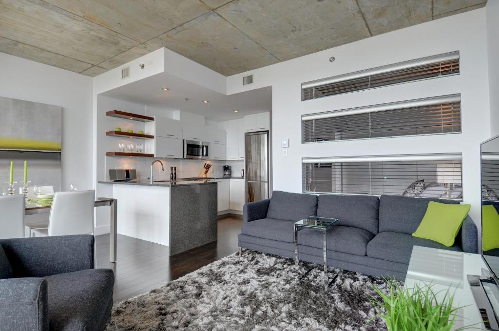 a living room with a couch and a kitchen at Les Immeubles Charlevoix - Le 760-431 in Quebec City