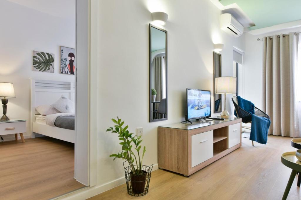 a bedroom with a bed and a television in a room at Mimosa Residenza in St. Julianʼs