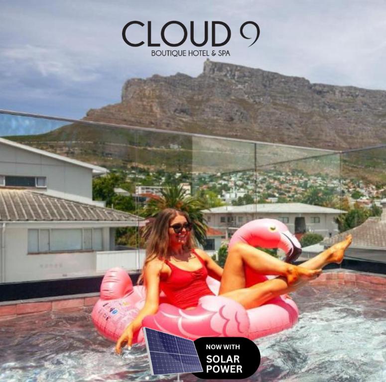 Eine Frau in einem roten Bikini, die auf einem aufblasbaren Bett sitzt. in der Unterkunft Cloud 9 Boutique Hotel and Spa in Kapstadt