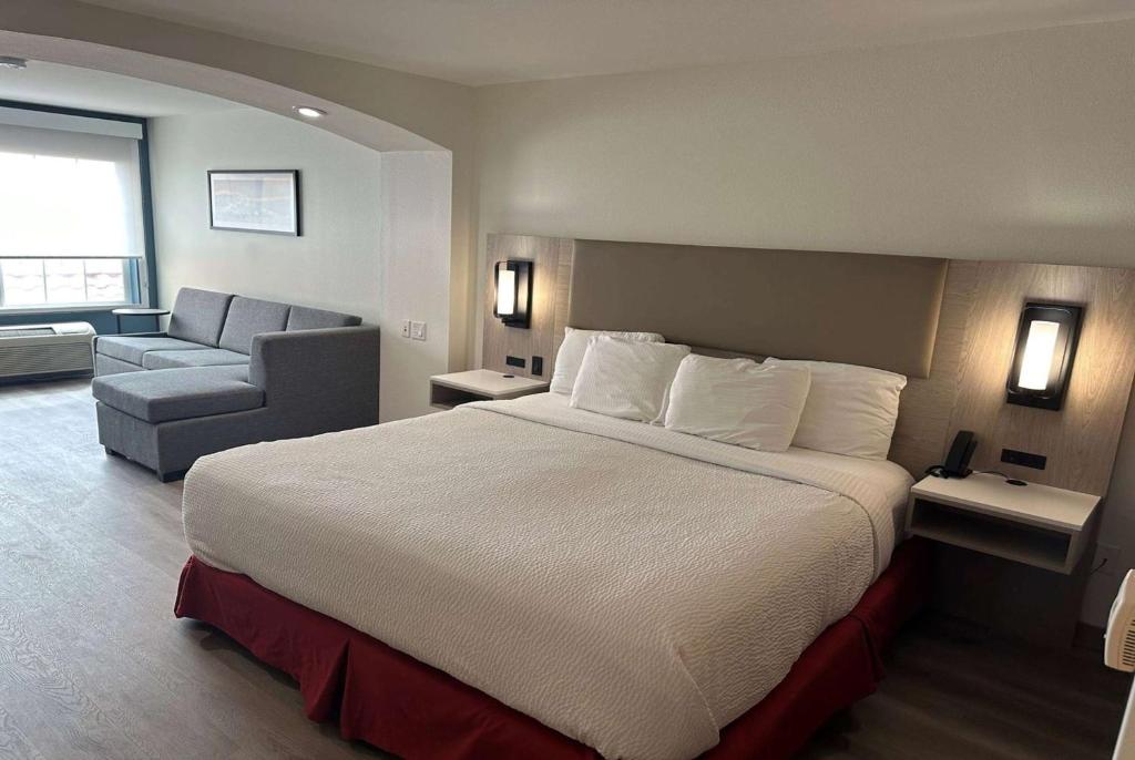 ein Hotelzimmer mit einem großen Bett und einem Sofa in der Unterkunft La Quinta by Wyndham Albuquerque Midtown NEWLY RENOVATED in Albuquerque