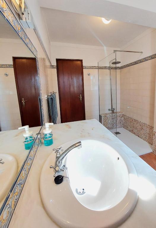 a bathroom with a white sink and a shower at Hakuna matata in Benagil