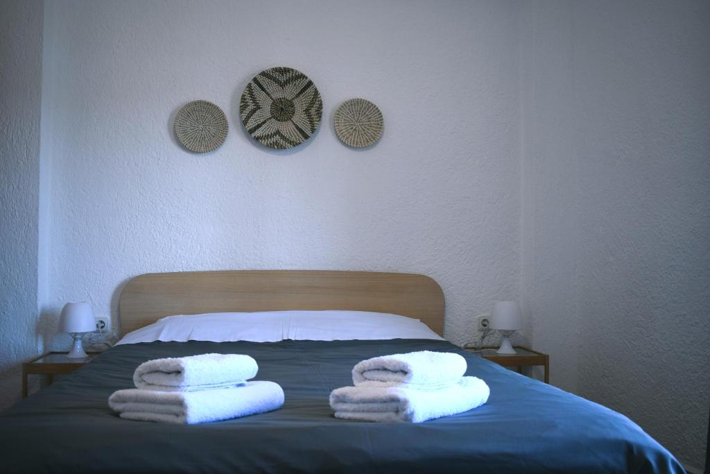 a bed with three towels on top of it at Boho Sea View Apartment in Elounda