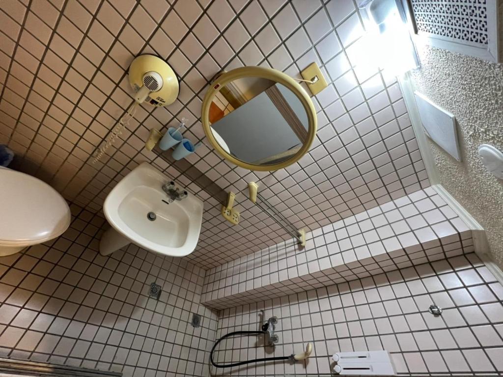 a bathroom with a mirror and a sink at Boston Hotel in Chiayi City