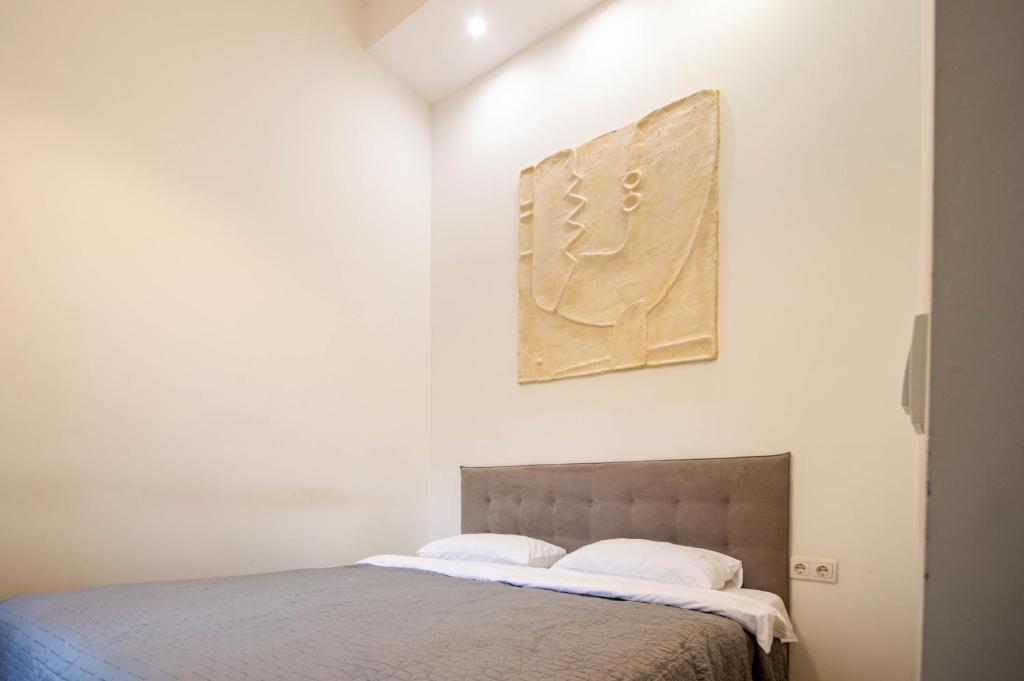 sypialnia z łóżkiem i obrazem na ścianie w obiekcie Kyiv 2Rooms White Apartment w Kijowie