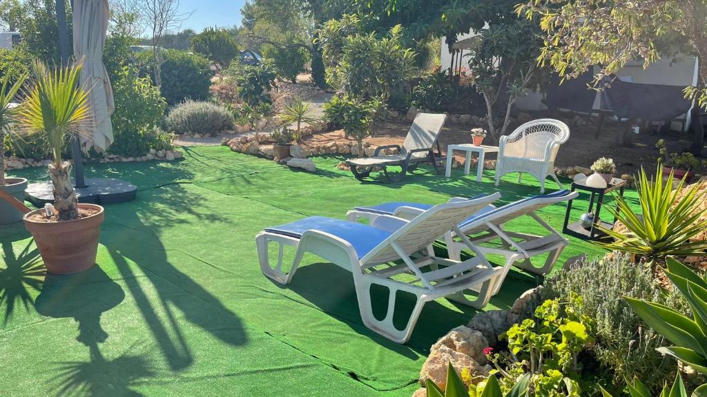 a yard with lawn chairs and a table and sidx sidx sidx sidx at Hakuna matata in Benagil