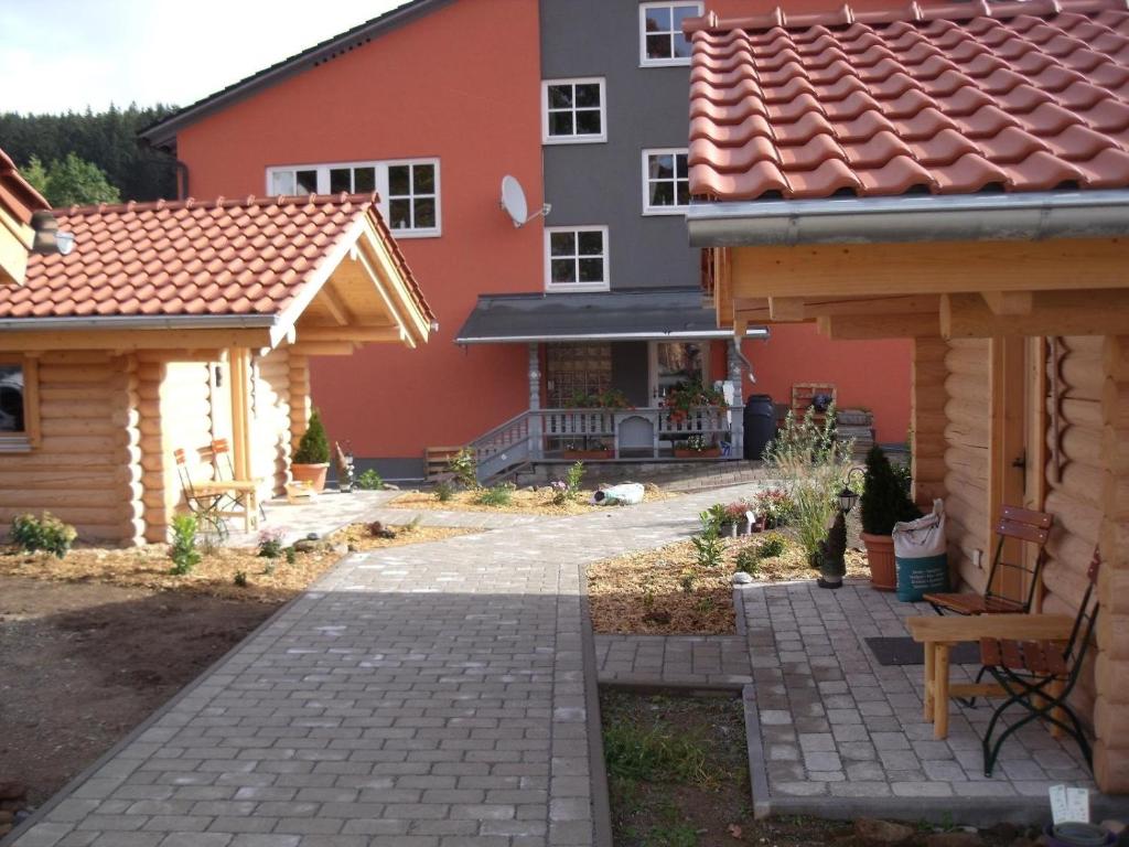 una casa con patio y una casa con techo en Pension Hüttendorf 49 gradnord, en Bayerisch Eisenstein