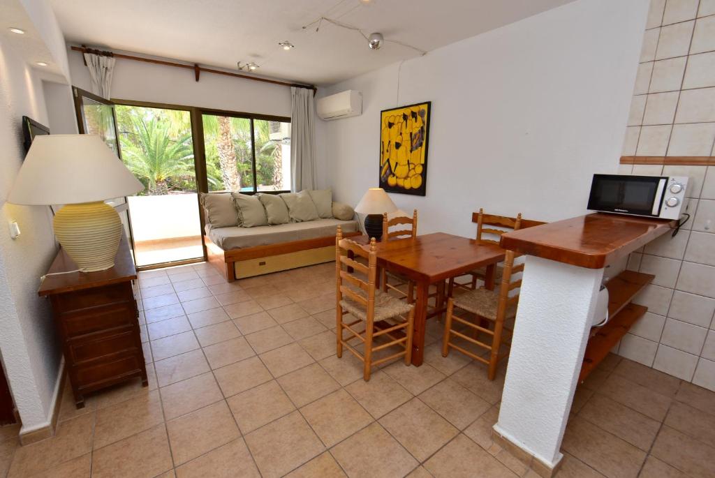 uma sala de estar com um sofá e uma mesa em Costamar 13 em Es Pujols
