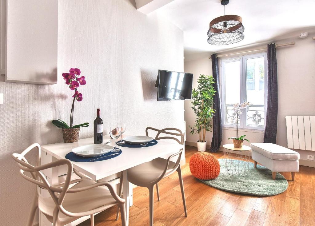 ein Esszimmer mit einem weißen Tisch und Stühlen in der Unterkunft 833 - Charming studio in Paris Olympic Games 2024 in Paris