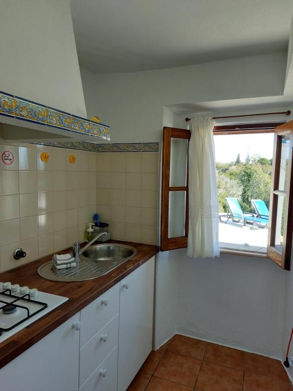 a kitchen with a sink and a window at Hakuna matata in Benagil