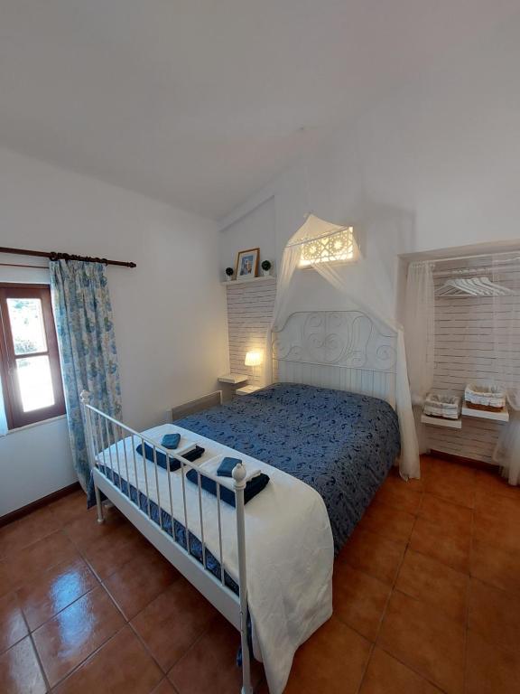 a bedroom with a bed in a room with a window at Hakuna matata in Benagil