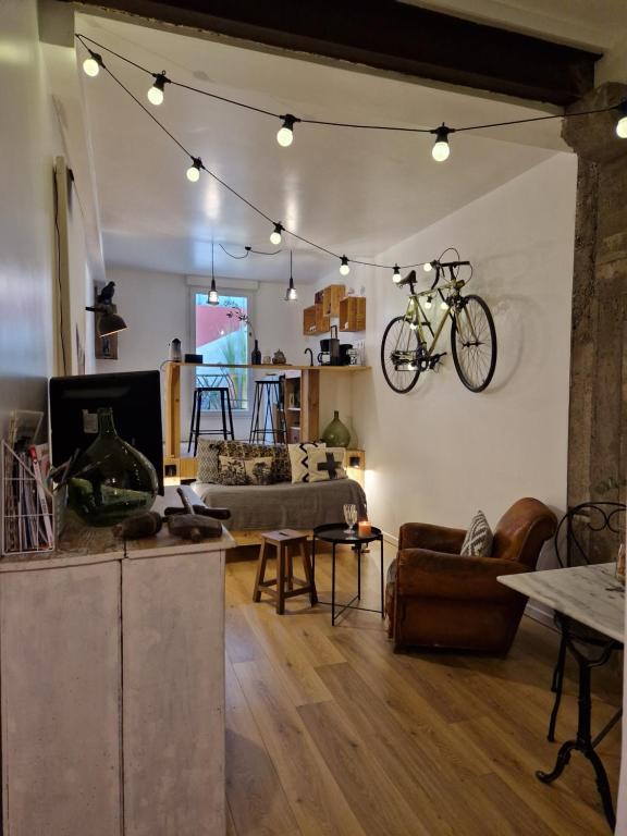 a living room with a bike hanging on the wall at Baptiste le caviste in Talence