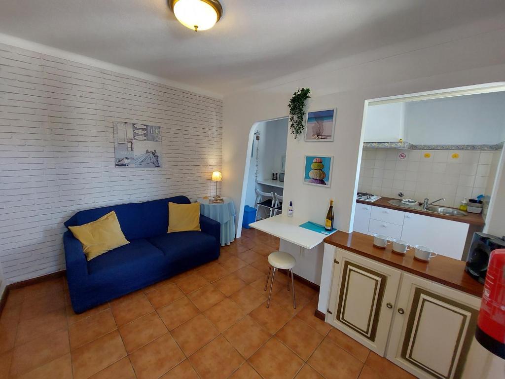 a living room with a blue couch and a desk at Hakuna matata in Benagil