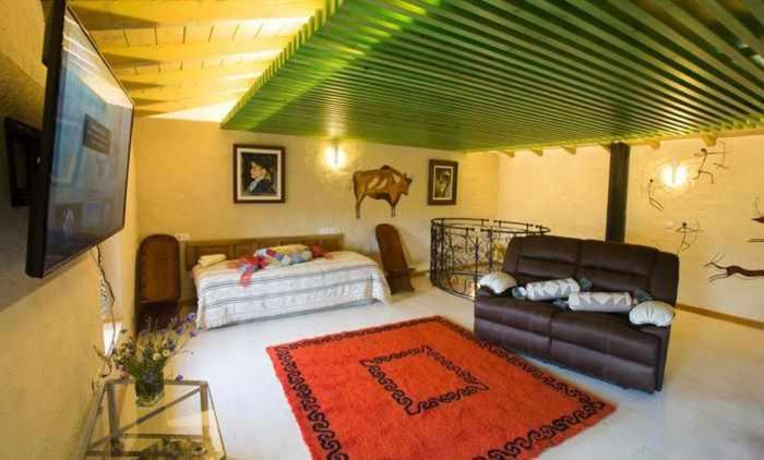 a living room with a couch and a bed at Casa del Cerro es una singular casa rural de fácil acceso in Cabezas Bajas