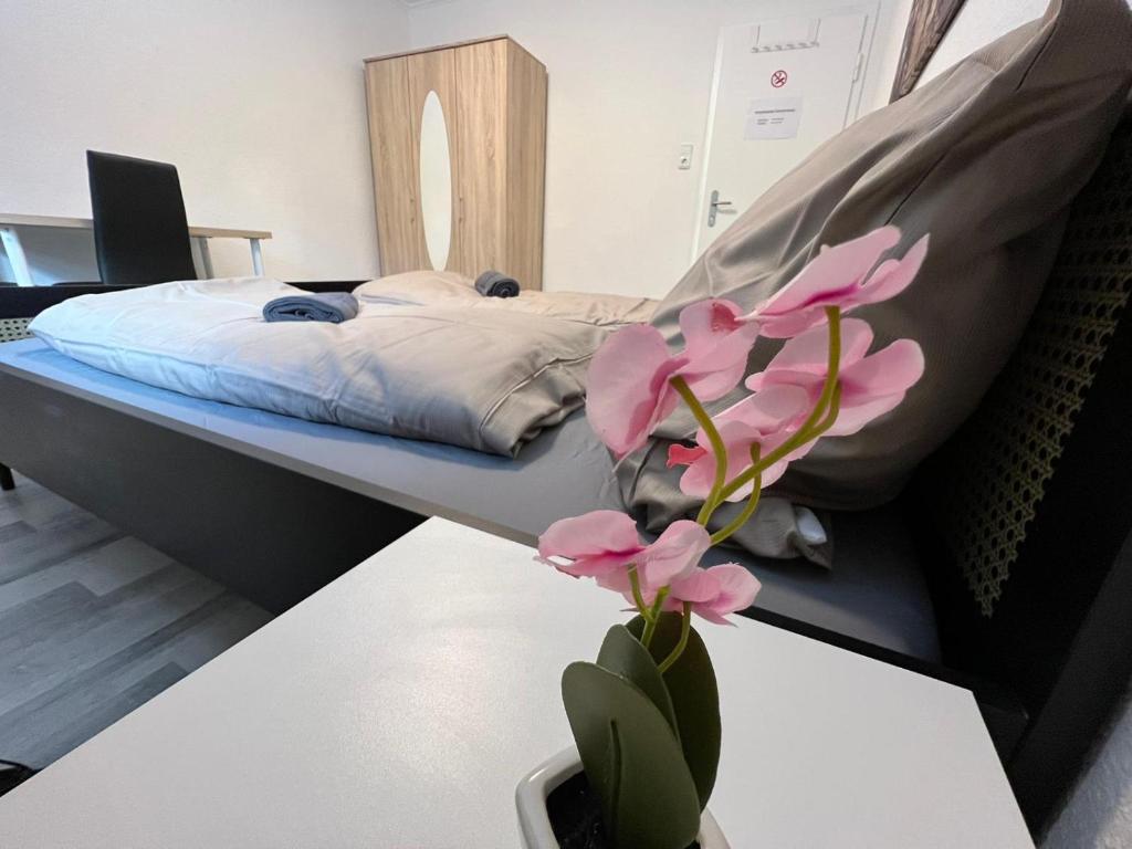 a bedroom with a bed and a vase with flowers on a table at OELTALAS Immobilien GmbH in Oldenburg