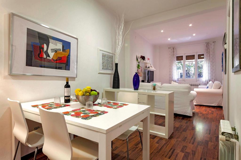 un comedor blanco con una mesa y sillas blancas en Barcelona Comtal Apartments, en Barcelona