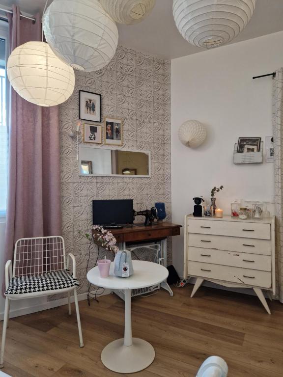 - un salon avec deux chaises, une table et deux lumières dans l'établissement Alixe la styliste, à Talence