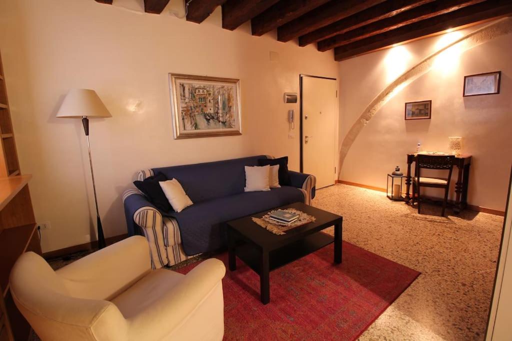 a living room with a blue couch and a table at San Marco charming apartment with canal view in Venice