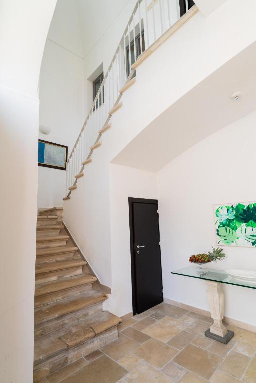 a stairway with a black door and a glass table at Palazzo Indelli in Monopoli