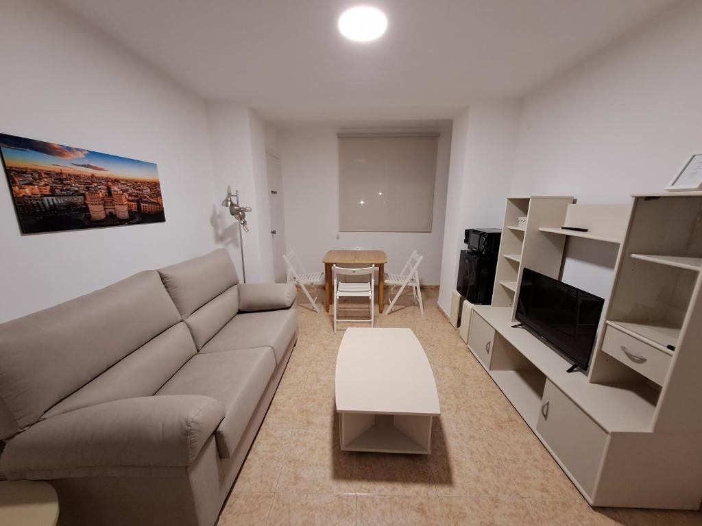 ein Wohnzimmer mit einem Sofa und einem Tisch in der Unterkunft Suite familiar Portalet in Benaguacil