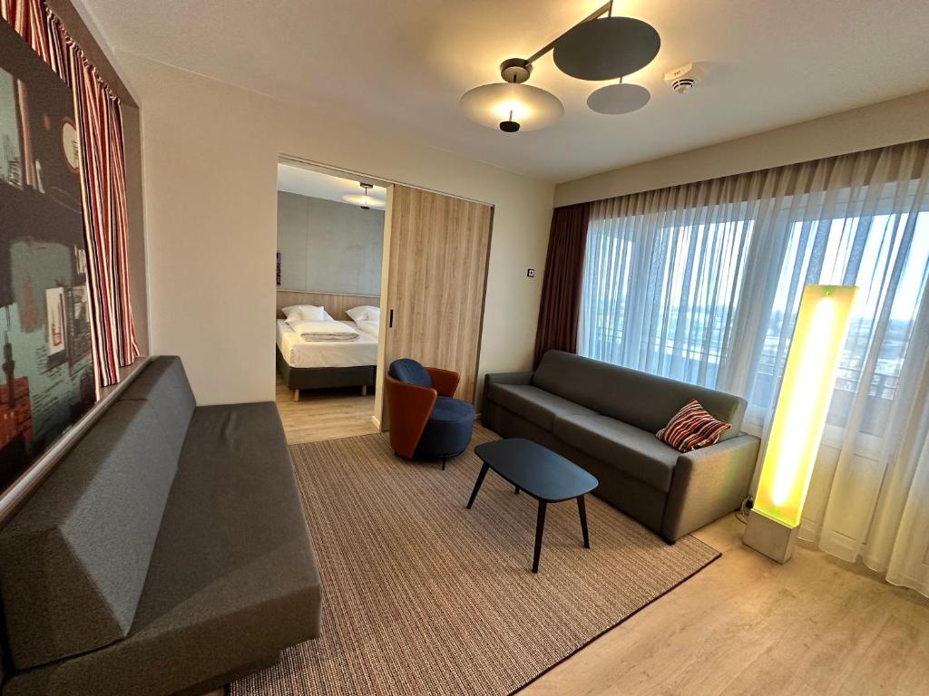 a living room with a couch and a bed at Apartment-Hotel Hamburg Mitte in Hamburg