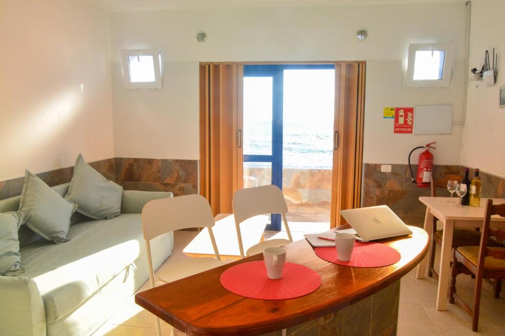 uma sala de estar com um sofá e uma mesa com um computador portátil em Apartamentos Playa Azul em Vallehermoso