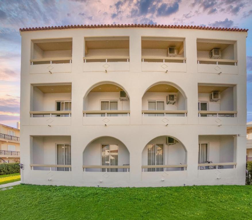 an apartment building with balconies and green grass at Lefteris Apartments in Ialysos Rhodes in Ialysos