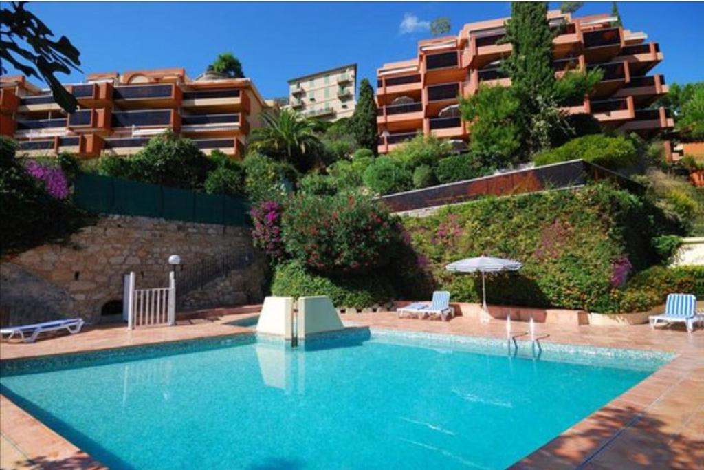 a large swimming pool in front of a building at Le Golfe bleu in Roquebrune-Cap-Martin