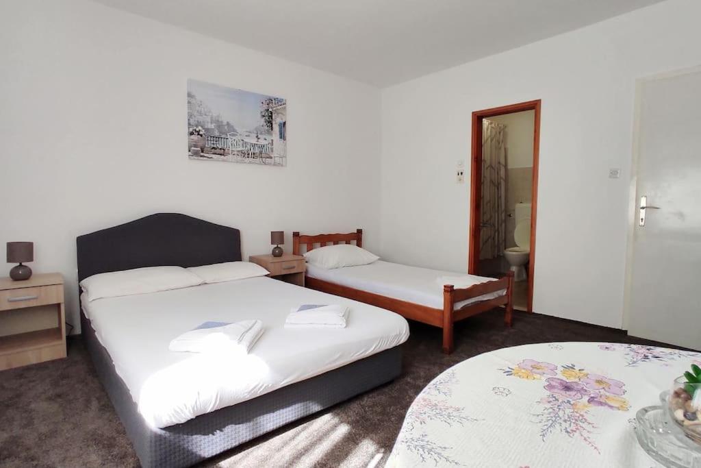 a hotel room with two beds and a mirror at Private En Suite Room Matkovic. Kotor Bay in Bijela