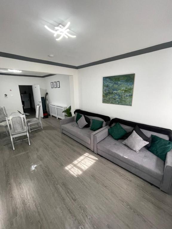 a living room with a couch and a ceiling fan at Monochrome Emerald in Brentwood