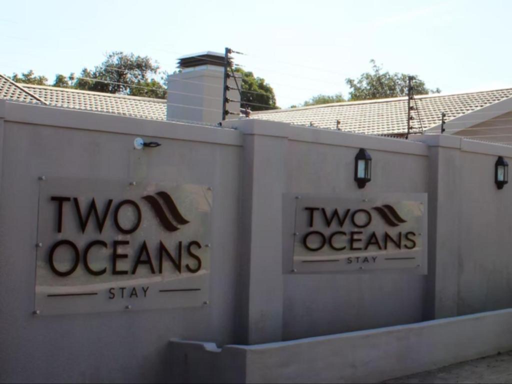 dos signos oceánicos en el costado de un muro en Two Oceans Stay en Ciudad del Cabo