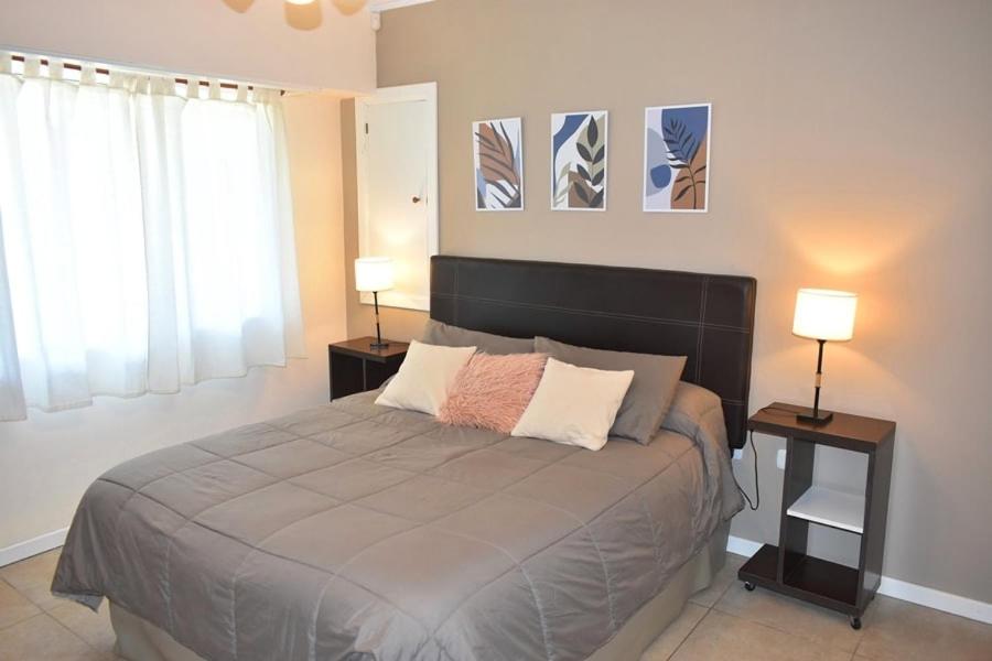 een slaapkamer met een groot bed en 2 lampen op tafels bij Icalma De La Sierra in Tandil