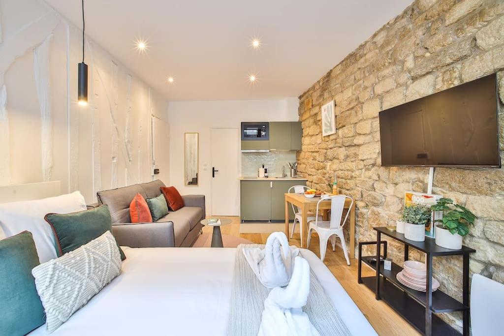 - un salon avec un canapé blanc et un mur en pierre dans l'établissement Studio 2pers#Mouffetard#Port-Royal#La Sorbonne, à Paris
