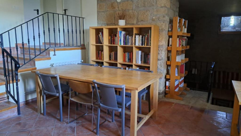a table and chairs in a room with a book shelf at Albergue de Sos del Rey Católico in Sos del Rey Católico