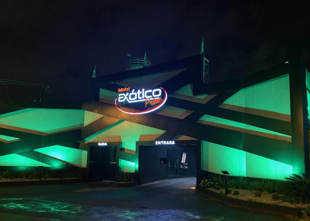 un bâtiment avec un panneau de néon la nuit dans l'établissement Exótico Prime Motel, à Ribeirão Preto