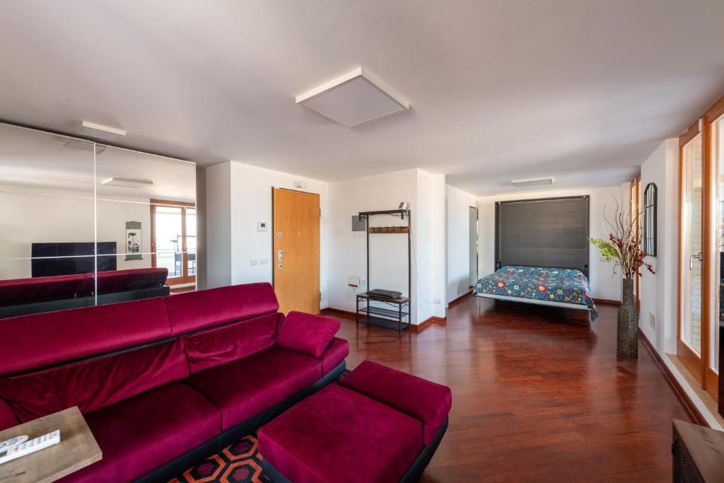 uma sala de estar com um sofá vermelho e uma cama em Casa Andrew New em Roma