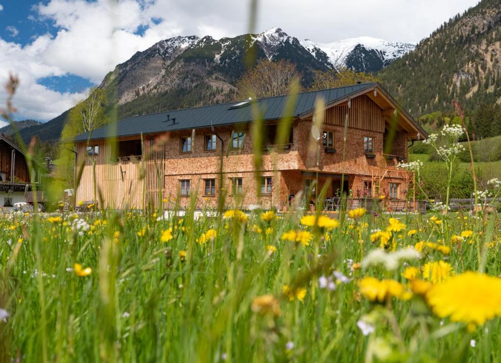 ein Blumenfeld vor einem Gebäude in der Unterkunft Ferienwohnungen Weiler in Oberstdorf