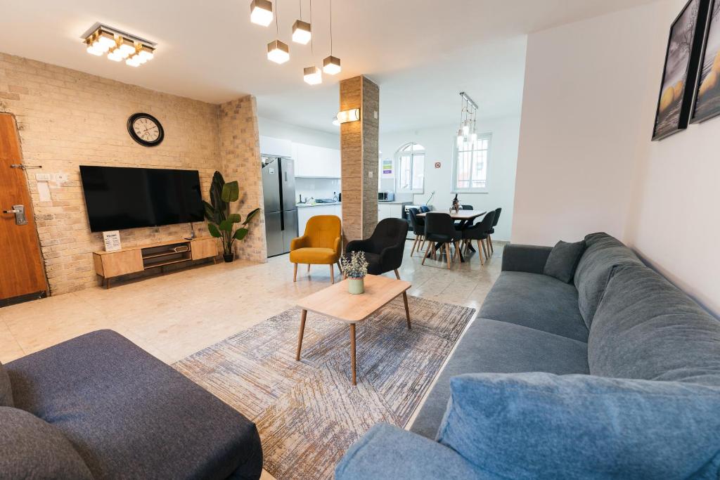 a living room with a couch and a dining room at ARISTO Machne Yehuda boutique apartments in Jerusalem