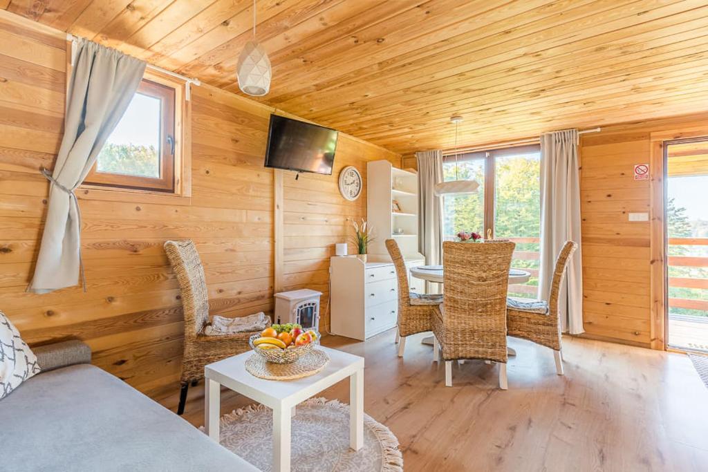 ein Wohnzimmer mit einem Sofa und einem Tisch in der Unterkunft ZACISZE Domek na Kaszubach Brodnica Dolna z balią z jacuzzi in Brodnica Dolna