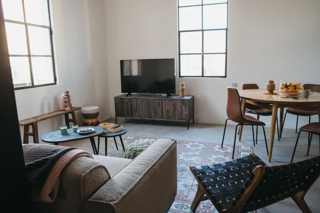 uma sala de estar com um sofá e uma televisão em Beautiful Bohemia apt in Jaffa em Tel Aviv