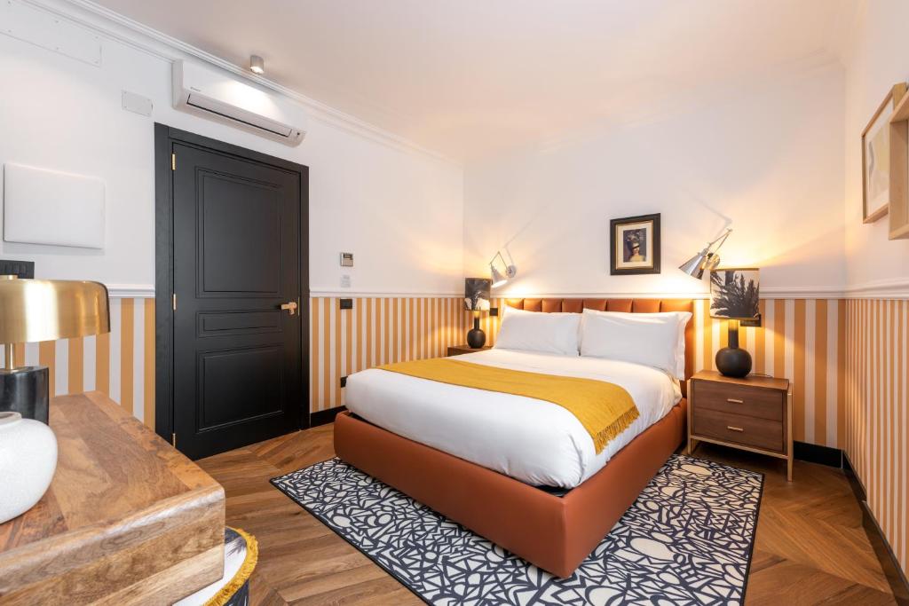 a hotel room with a bed and a desk at DH Rooms Spiga in Milan
