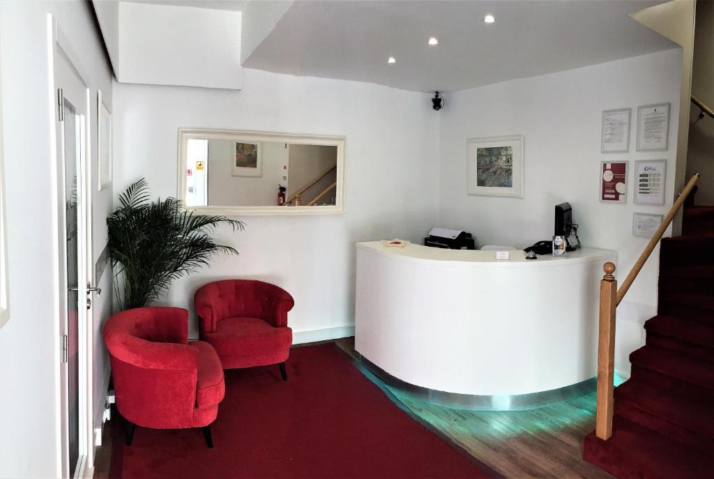 une chambre avec deux chaises rouges et un comptoir dans l'établissement The Capital Boutique B&B, à Peniche