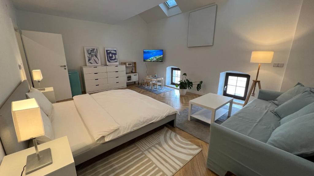 a bedroom with a large bed and a couch at Franco Apartments in Kežmarok