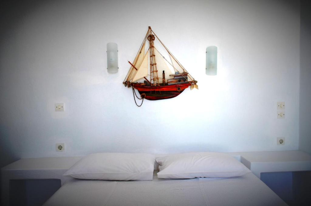 a small boat hanging on a wall above a bed at Summer Residence in Provatas