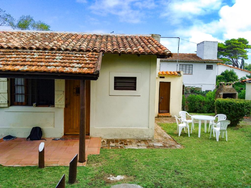una pequeña casa con una mesa y sillas en el patio en Casa a 3 cuadras del mar, zona centro en Villa Gesell