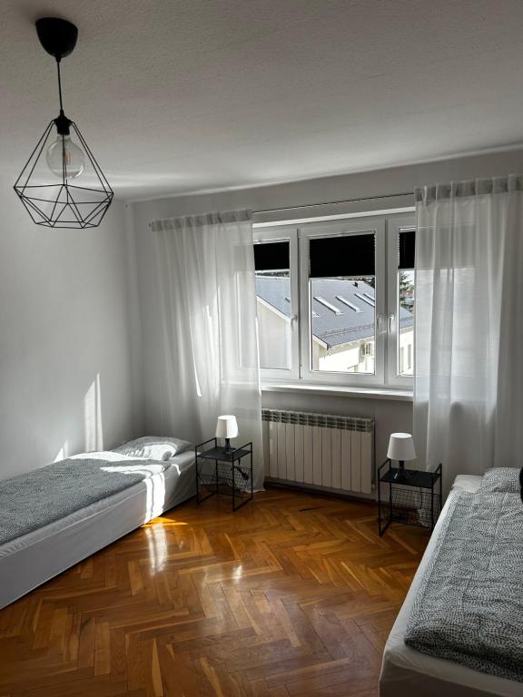 - une chambre avec 2 lits et une grande fenêtre dans l'établissement Hostel Centrum NT, à Nowy Tomyśl